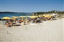 Písečná pláž se slunečníky, Punta Marana, Sardinie