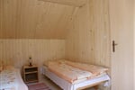 Pokoj s lůžky, nočními stolky a lampičkami v podkroví