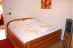 Ložnice s manželskou postelí a televizorem apartmánu Serles