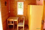 Interiér bungalovu se stolkem, židlemi a skříněmi