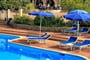 Lehátka se slunečníky u bazénu, Golfo di Marinella, Sardinie
