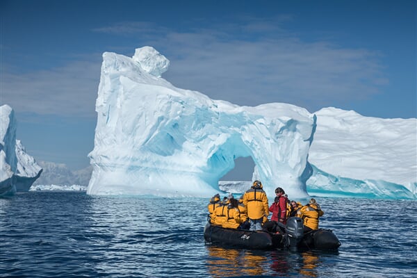 Eleven guests and an Expedition Guide witness a massive iceberg as they stop at a safe distance to capture photographs. Always follow the advice of your Expedition Guides to ensure your safety and a flowless experience while zodiac cruising. 