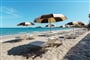 Hotelová pláž s lehátky a slunečníky, Pula, Sardinie