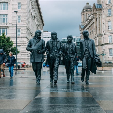 Kráčející skupina Beatles v ulicích Liverpoolu