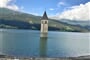 Cyklotrasa vede kolem jezera Reschensee s ikonickým potopeným kostelem.