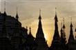 Západ slunce mezi věžemi a stupami buddhistického chrámu.