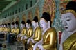 Řada pozlacených soch Buddhy v jednom z barevných chrámů oblasti Sagaing