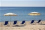 Pláž s lehátky a slunečníky, Pula, Sardinie