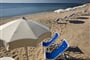 Pláž s lehátky a slunečníky, Pula, Sardinie