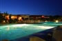Noční pohled na bazén Hotelu Le Sabine s barem, Badesi, Sardinie