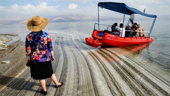 Loďka s turisty vyplouvá od břehu Mrtvého moře